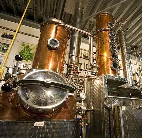 Koperen distilleerketel en distillatiekolom in de stokerij